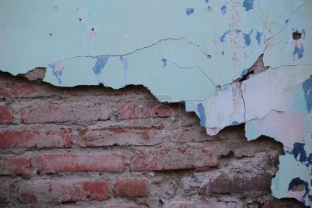 Aged Weathered Brick Wall with Cracked Paint and Exposed Bricks