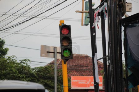 Traffic lights at urban intersection with electricity poles in the background