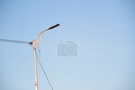 a solar-powered street light with a clear blue sky background.