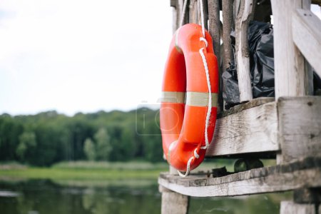 Téléchargez les photos : Bouée de sauvetage sur la jetée avec lac à l'arrière-plan - en image libre de droit