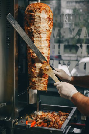 Foto de Hombre cortando carne turca kebab en la calle - Imagen libre de derechos