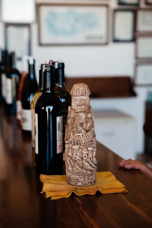 Foto de Botella de vino vintage hecha de arcilla sobre fondo de madera - Imagen libre de derechos