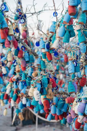Téléchargez les photos : Petites cruches multicolores avec inscriptions, vœux suspendus sur les branches d'un arbre - en image libre de droit
