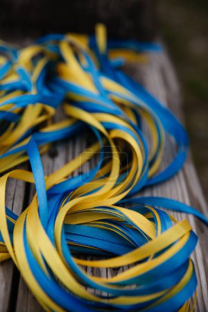 Téléchargez les photos : Vue rapprochée des rubans bleus et jaunes sur fond bois - en image libre de droit