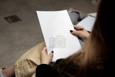Téléchargez les photos : Image recadrée d'une jeune femme tenant du papier vierge - en image libre de droit