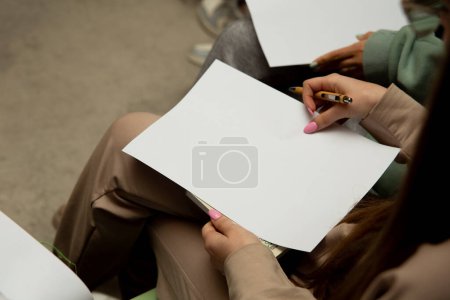 Téléchargez les photos : Image recadrée d'une jeune femme tenant du papier vierge - en image libre de droit