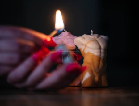 Photo for Woman set fire candles in the beautiful shape of a woman's and man's body with soy wax. - Royalty Free Image