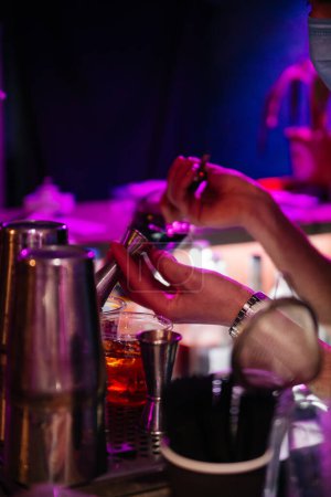Photo for Expert barman is making cocktail at night club - Royalty Free Image
