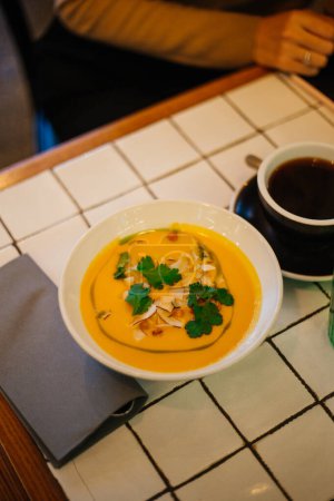 Pumpkin cream soup with parsley and mushrooms on the table 