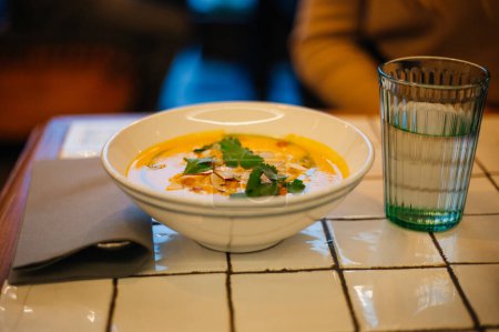 Pumpkin cream soup with parsley and mushrooms on the table 