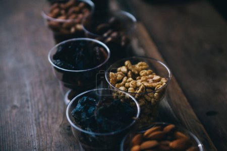 Téléchargez les photos : Vue rapprochée de délicieux raisins secs et noix dans des verres en plastique - en image libre de droit