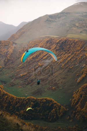 Photo for Stepantsminda, Georgia - October 17, 2021: Paraglider flying near Mount Kazbek in Georgia - Royalty Free Image