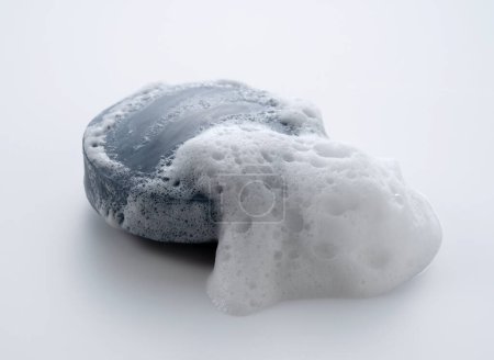 Foto de Jabón sólido con espuma colocada sobre fondo blanco. Vista desde arriba. - Imagen libre de derechos