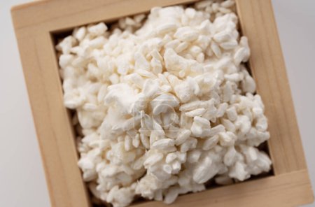 Foto de Rice koji in a box placed on a white background. Koji mold. Koji is fermented rice. A view from directly above. - Imagen libre de derechos