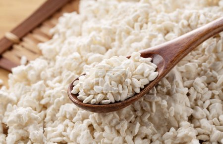 Foto de Rice koji in a colander on the table and a wooden spoon. Koji. Koji is fermented rice. - Imagen libre de derechos