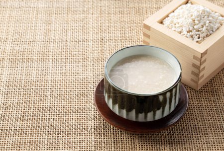 Amazake et malt de riz dans une boîte Masu sur la table. Amazake est une boisson sucrée japonaise traditionnelle. Koji est du riz fermenté.