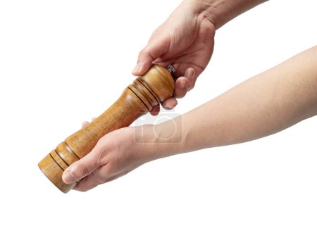 Wooden pepper mill in men's hand isolated on white background.