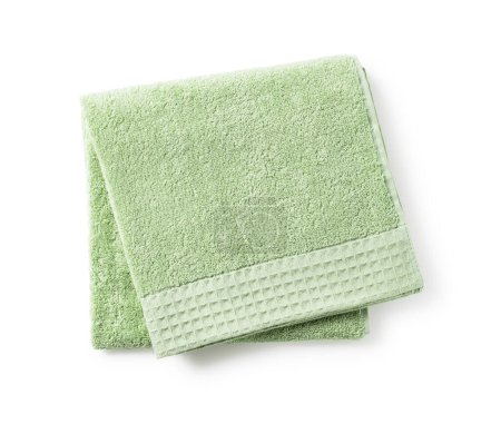 Green towel placed on white background. View from directly above.