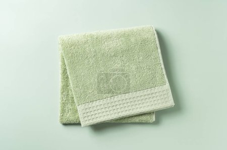 Green towels placed on a green background. View from directly above.