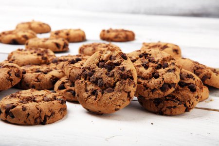 Téléchargez les photos : Biscuits au chocolat sur table en bois blanc. Cookies aux pépites de chocolat - en image libre de droit