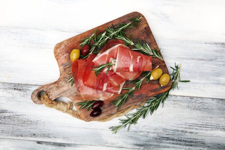 Téléchargez les photos : Crudo au prosciutto italien ou jamon au romarin. Apéritif jambon cru - en image libre de droit