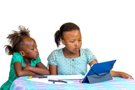 Foto de Portrait of Two little African kids looking together at digital tablet at table. Isolated on white background. - Imagen libre de derechos