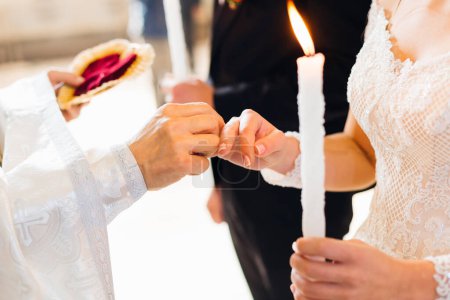 Foto de Los novios en la iglesia frente al sacerdote. voto e intercambio de anillos de boda - Imagen libre de derechos
