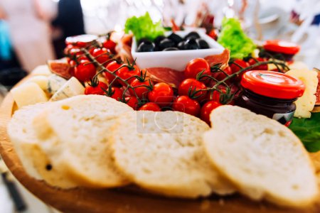 Foto de Primer plano de rebanadas de pan, queso y jamón. rama con tomates, salsa y aceitunas - Imagen libre de derechos