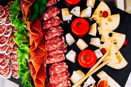 Téléchargez les photos : Vue de dessus sur l'assiette avec différentes viandes, fromages et laitues. réception de mariage - en image libre de droit