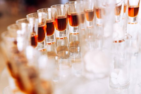 Téléchargez les photos : Gros plan d'un verre à vin avec une boisson alcoolisée sur un stand transparent. - en image libre de droit