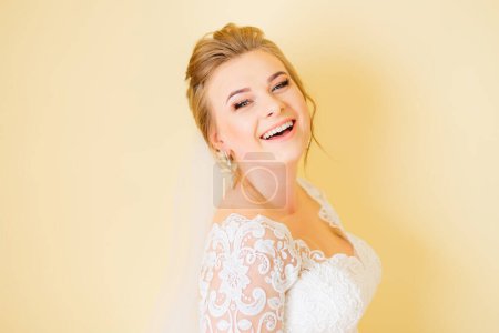Foto de Feliz novia sonriendo y mirando a la cámara. vestido de novia blanco con un patrón. - Imagen libre de derechos