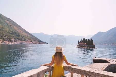 Foto de Mujer en vestido amarillo disfrutando de la vista sobre la bahía en Montenegro - Imagen libre de derechos