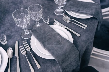 Foto de Decoraciones de mesa de color gris. Lujoso servicio de mesa elegante para un banquete de bodas. Estamos esperando al invitado. - Imagen libre de derechos