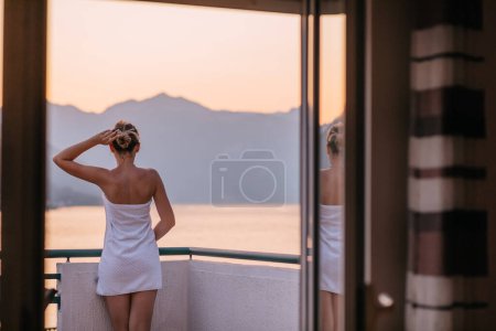 Photo for Woman on the balcony against the backdrop of mountains and city, Montenegro. life terrace pretty happiness summer home. Inspiration city romantic hotel - Royalty Free Image
