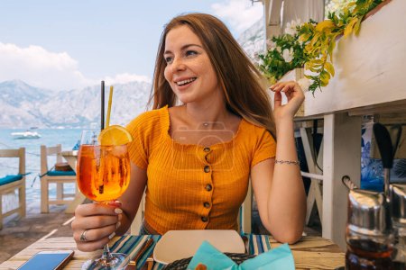 Photo for Woman drinking wine at restaurant on the street in Montenegro. - Royalty Free Image