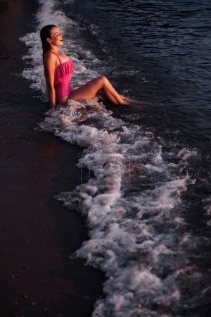 Foto de Una joven bañándose en la ola del mar con salpicaduras de agua - Imagen libre de derechos