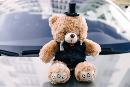 Photo for Teddy bear on car hood as a part of wedding decorations - Royalty Free Image
