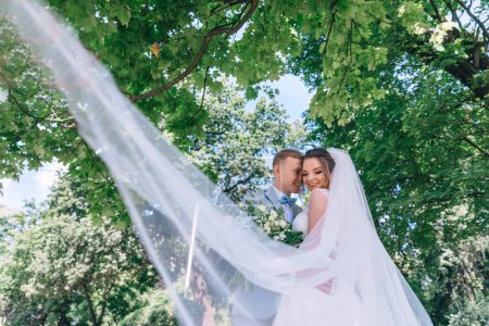 Photo for Bride and groom at wedding Day walking Outdoors on spring nature. Bridal couple, Happy Newlywed woman and man embracing in green park. - Royalty Free Image