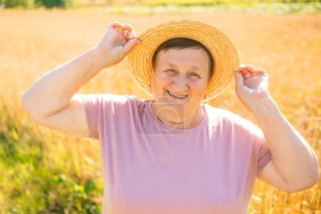 Foto de Retrato de una feliz mujer mayor sonriente en el campo de trigo - Imagen libre de derechos