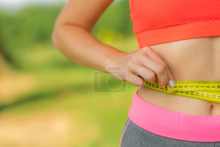 Photo for Sport girl measuring waist. Sports. Reducing excess weight. Healthy lifestyle. Copy space - Royalty Free Image