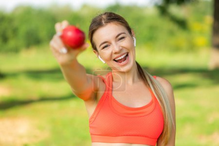 Foto de Feliz mujer deportiva sosteniendo manzana al aire libre - Imagen libre de derechos