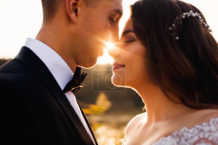Foto de Recién casados de pie cara a cara y ojos cerrados. el sol entre los recién casados. de cerca - Imagen libre de derechos
