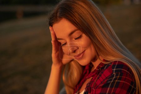 Photo for Outdoor atmospheric lifestyle photo of young beautiful lady. Blonde hair and closed eyes. Warm autumn. - Royalty Free Image