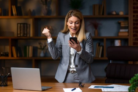 Téléchargez les photos : Portrait of young Happy excited  businesswoman in office working with mobile phone,Yes great job.Portrait of young Happy excited  businesswoman in office working with mobile phone,Yes great job. - en image libre de droit
