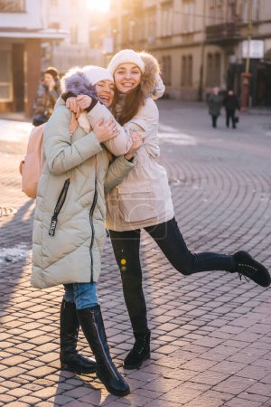 Téléchargez les photos : Deux petites amies heureuses embrassant dans la rue de la ville, moments drôles ensemble. Concept d'amitié - en image libre de droit