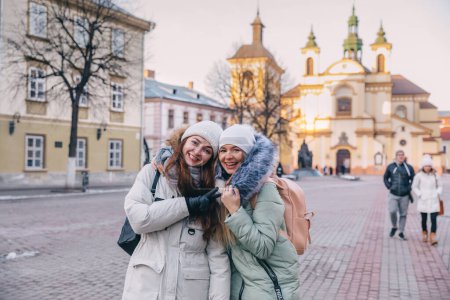 Photo for Two female tourist friends travel through cities, walk the streets, pose against the background of architecture. Fun and interesting trips together - Royalty Free Image