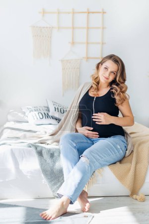 Téléchargez les photos : Beauté femme enceinte sourit mystérieusement regarde de côté les rêves d'un futur bébé. - en image libre de droit