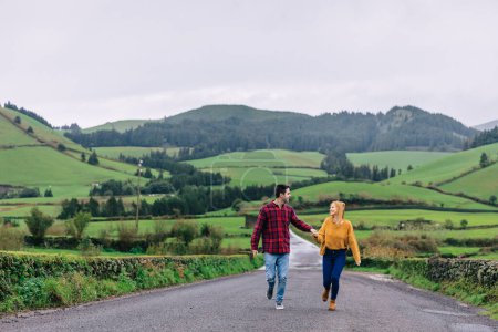 Téléchargez les photos : Un mec et une fille se tenant la main et se regardant. montagnes et forêt à l'arrière-plan - en image libre de droit