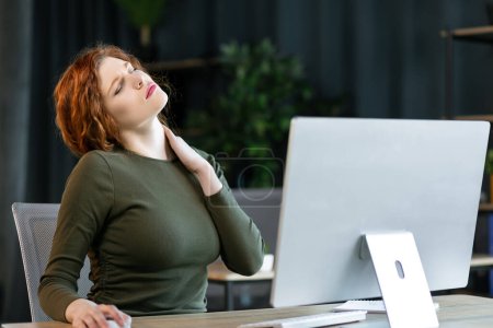 Photo for Businesswoman feeling pain in neck after sitting at the table . Tired female suffering of office syndrome because of long hours computer work. Pretty girl massaging her tense neck muscles - Royalty Free Image