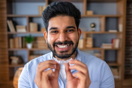 Photo for Handsome arab man with beard holding dental aligner with a happy face standing and smiling with a confident smile showing teeth - Royalty Free Image